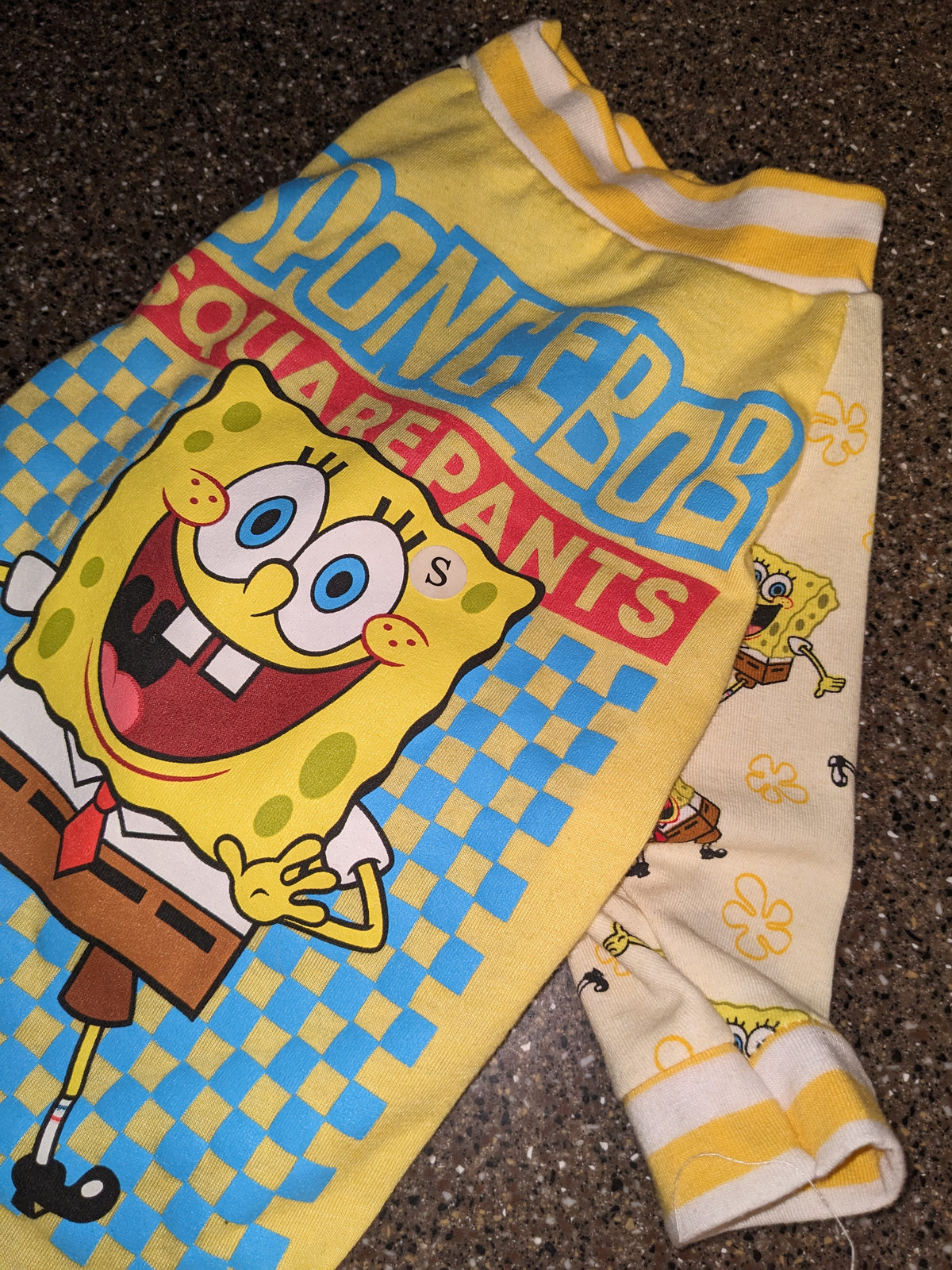 Small upcycled shirt for an Italian Greyhound with a SpongeBob SquarePants graphic on yellow and blue checks, flat lay