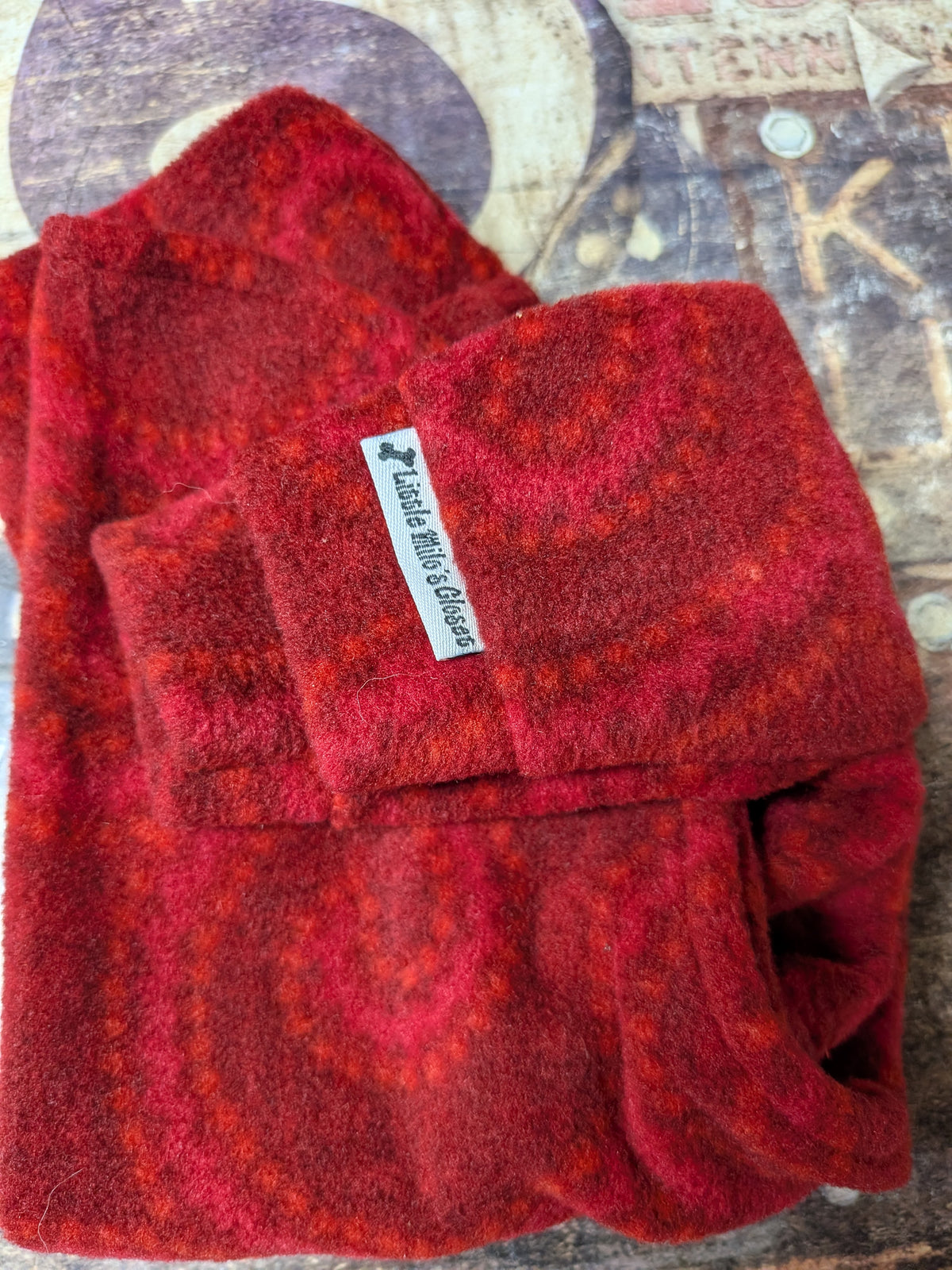 Red Swirl Christmas fleece top for Italian Greyhounds, folded red fleece with a Little Milo's Closet label