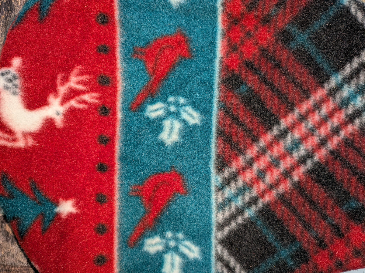 Close-up of red Christmas stripe fleece jammies with reindeer, cardinals, holly and plaid bands