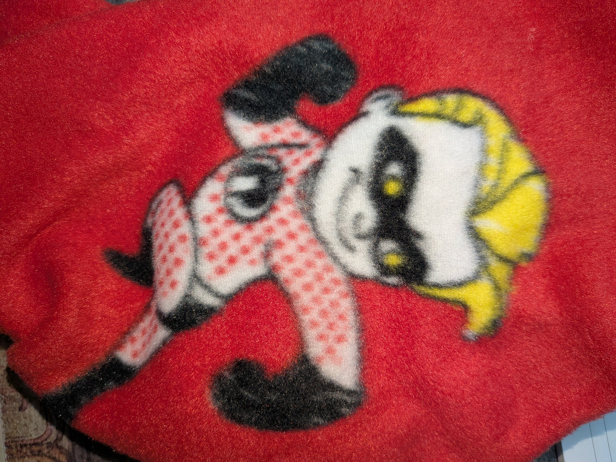 Close-up of red Christmas fleece jammies with a cartoon character in pink polka dot pajamas