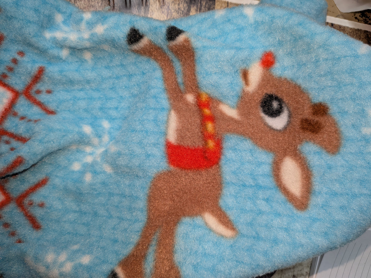 Close-up of light blue Reindeer fleece jammies with a red nosed reindeer and red snowflakes