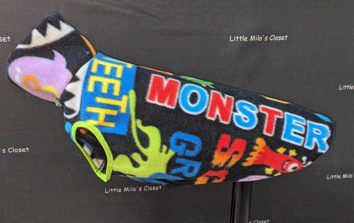 Monster fleece vest with bold MONSTER lettering in bright colors on black, on a dog form