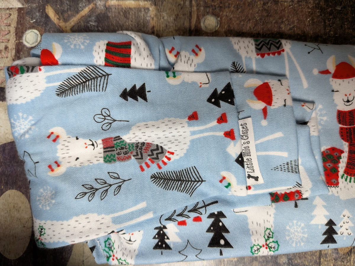 Folded light blue Llamas on Blue two legged Christmas top with llamas in sweaters and trees