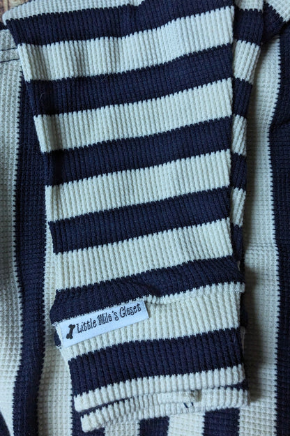Navy and cream striped knit Italian Greyhound sweater, folded close-up of the sleeve and label