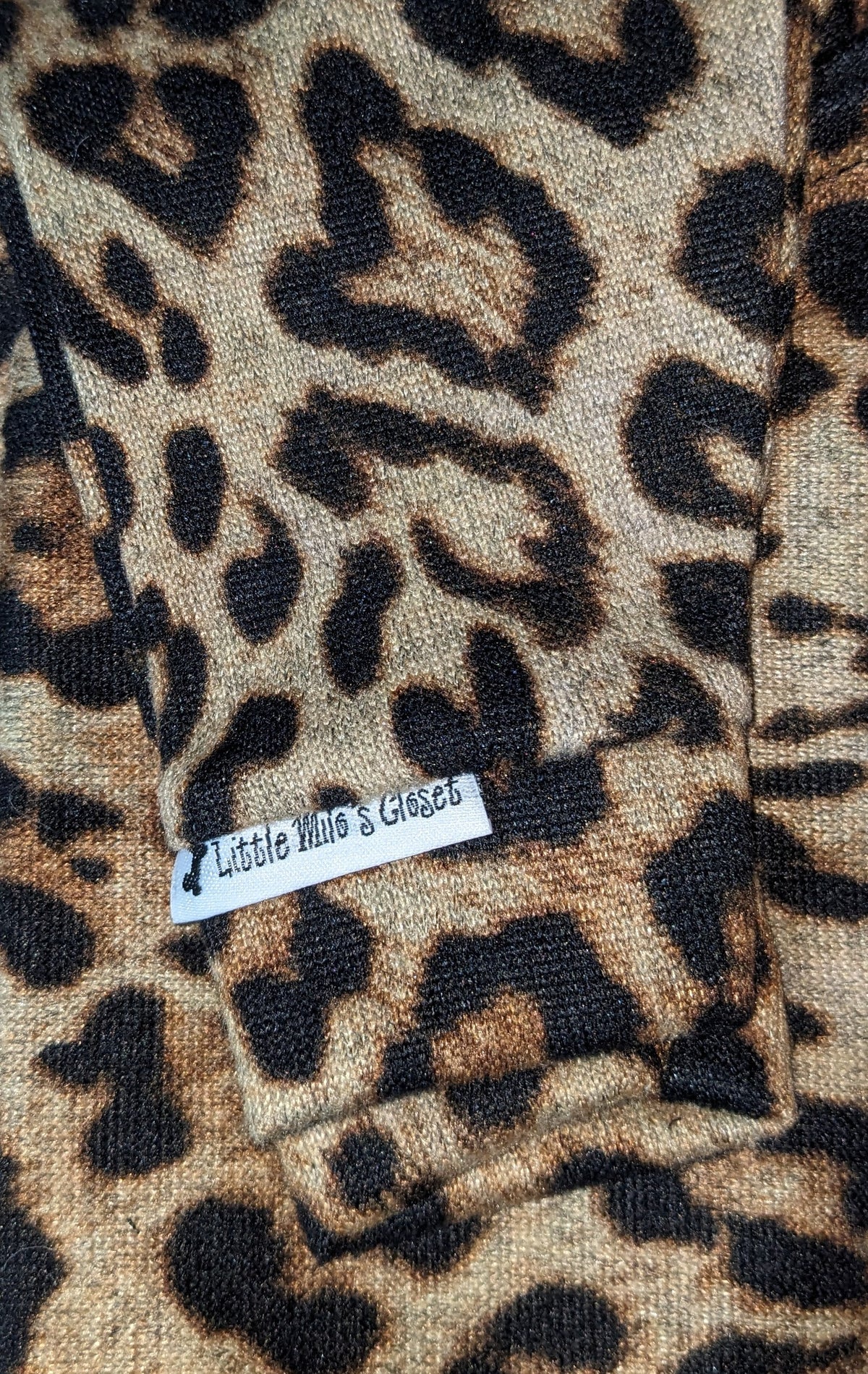 Cheetah print knit Italian Greyhound sweater, folded close-up of the sleeve with label