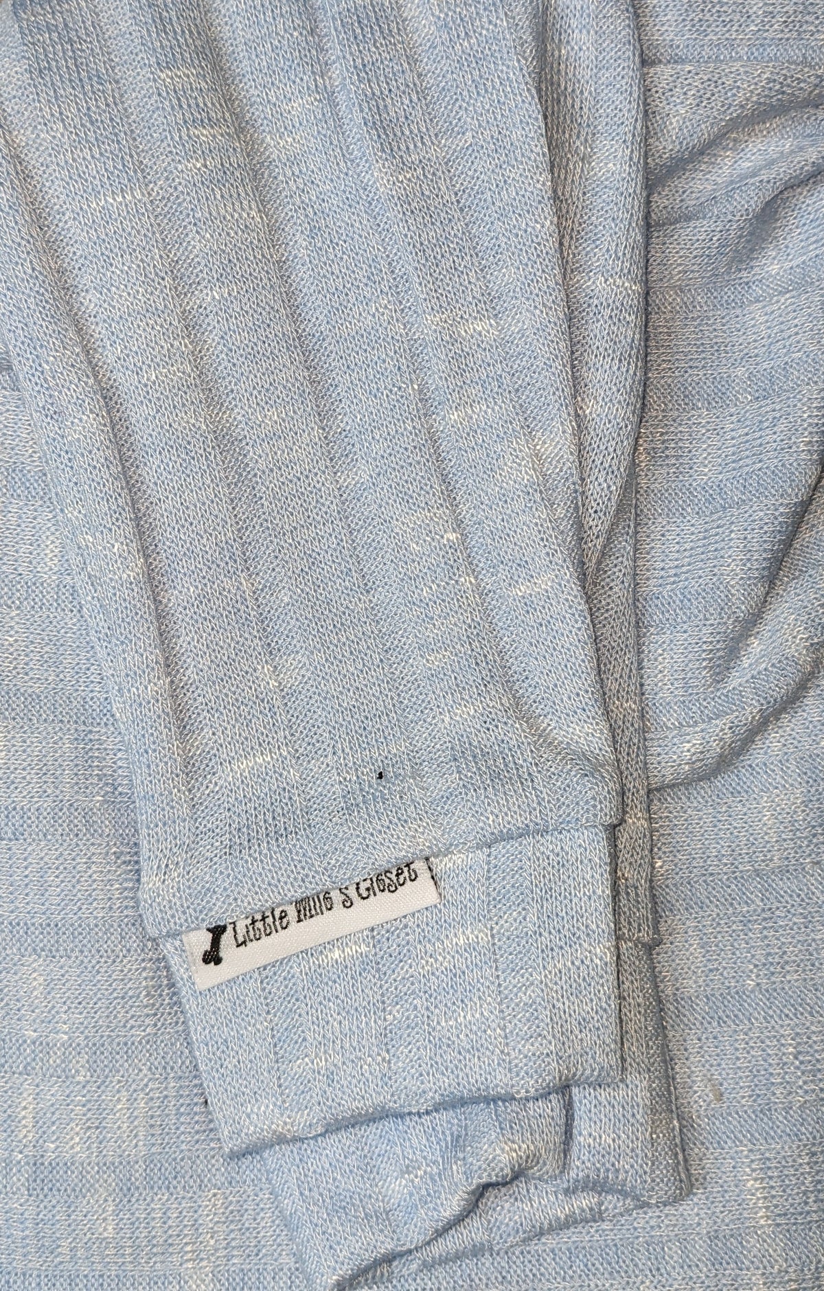 Light blue rib knit Italian Greyhound sweater, folded close-up of the sleeve