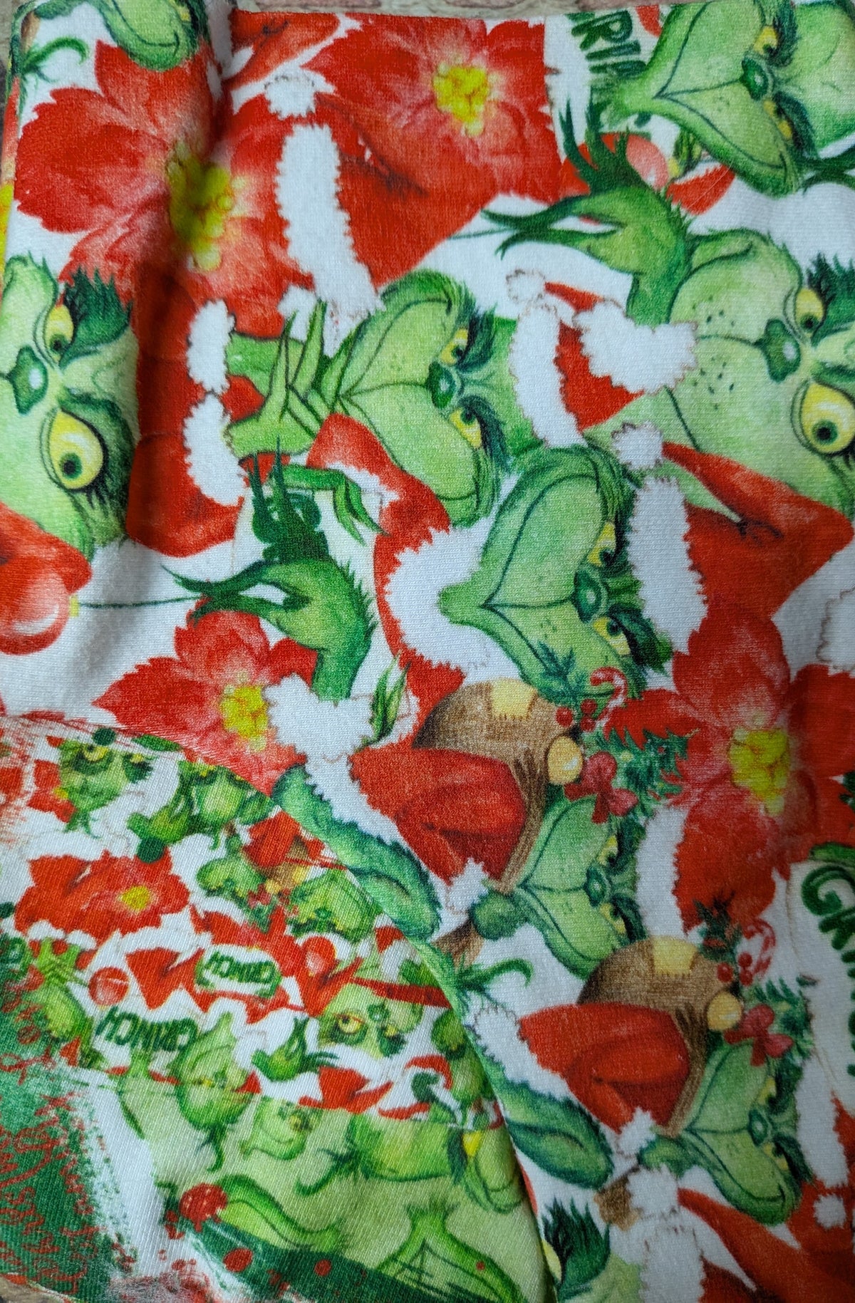 Grinch Christmas two legged Italian Greyhound top with green Grinch characters and red poinsettias, close-up