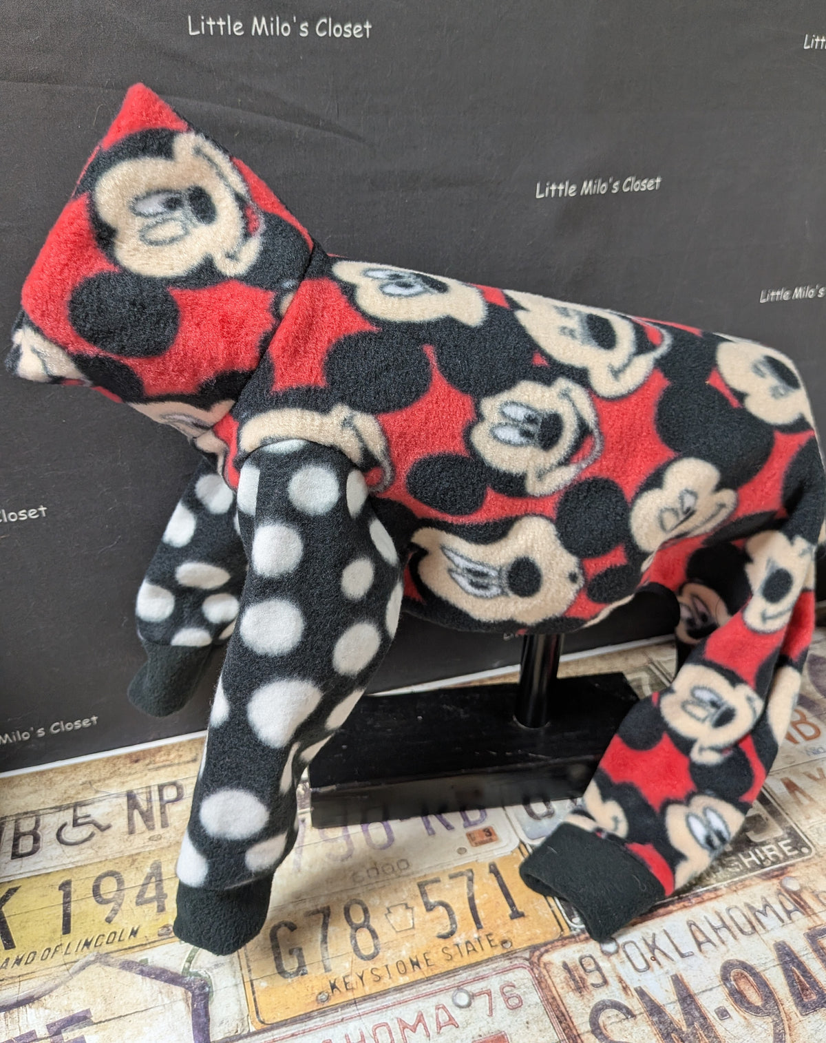 Red Mickey Mouse face fleece bodysuit with black and white polka dot legs, side view on a dog form