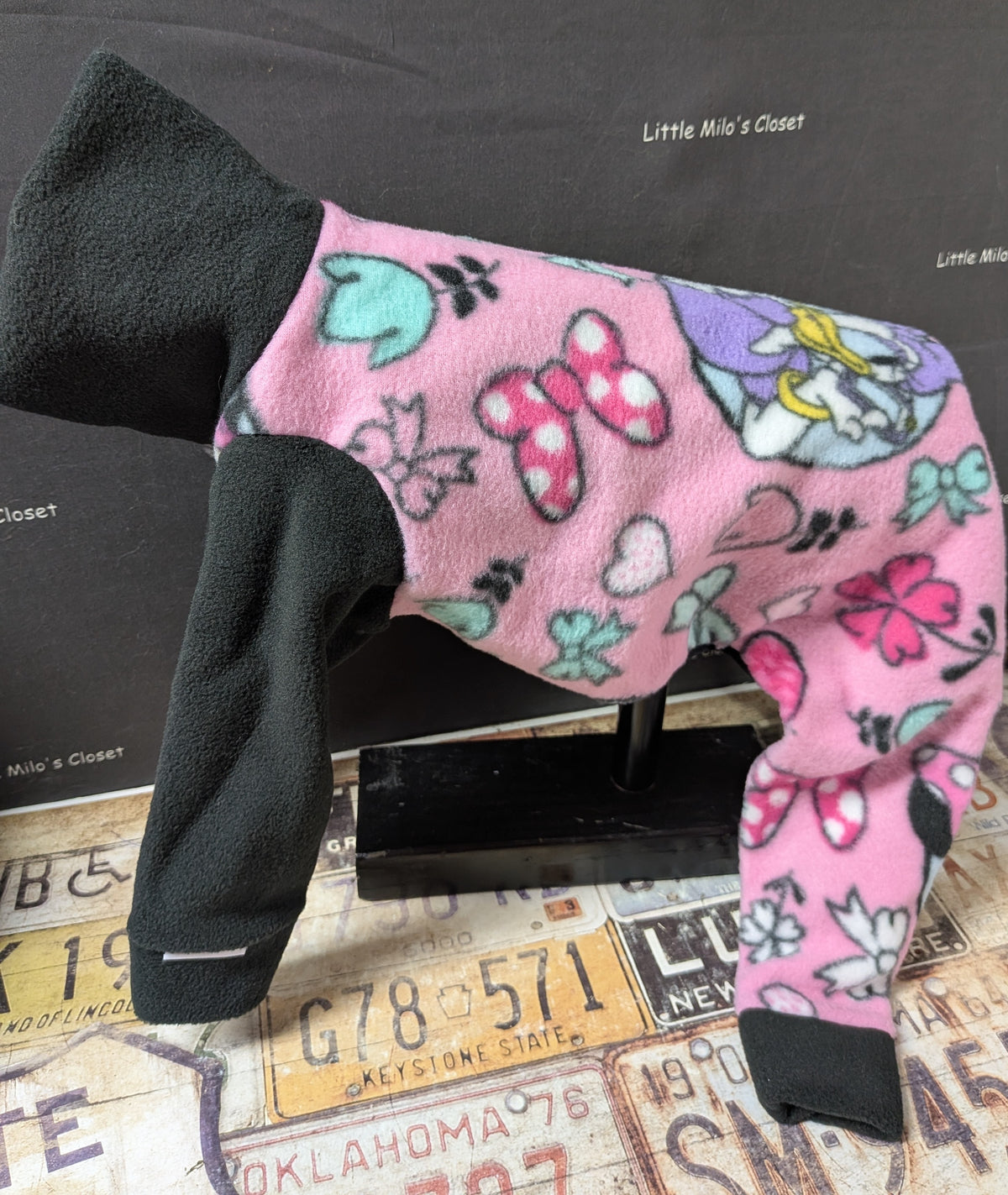 Pink Minnie and friends fleece bodysuit with black neck and front legs, side view on a dog form