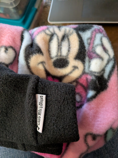 Folded pink Minnie and friends fleece Italian Greyhound bodysuit with a black cuff and brand label