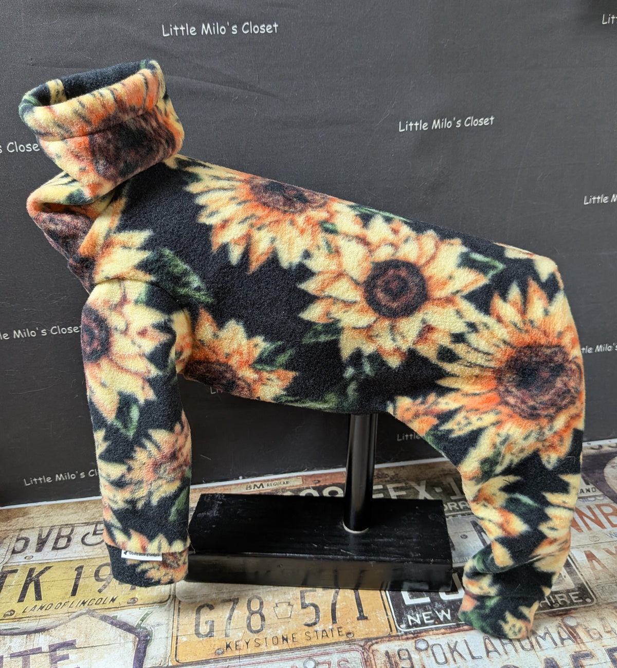 Sunflower fleece bodysuit for a medium Italian Greyhound, black with large yellow sunflowers, side view on a dog form