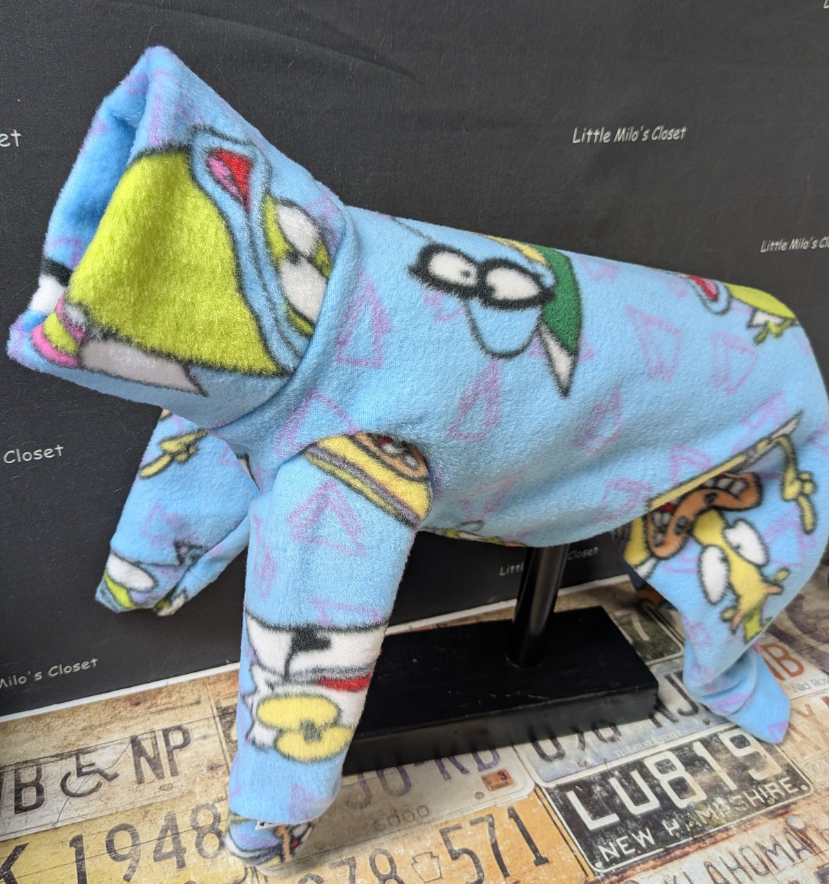 Light blue Ren and Stimpy cartoon fleece bodysuit with a lime green lined collar, front angle on a dress form