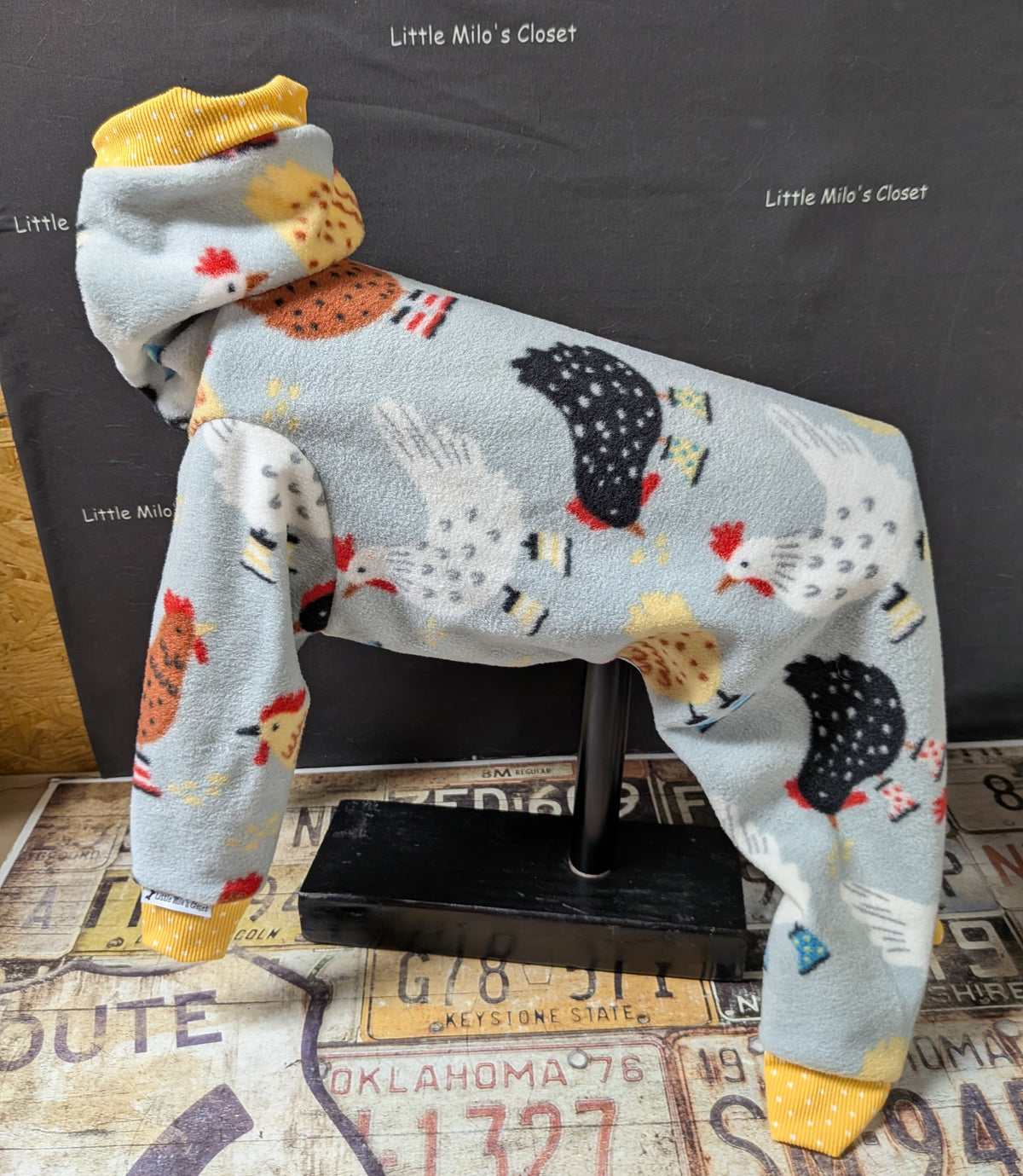 Chickens fleece bodysuit in blue grey with black and white hens and mustard yellow neck and cuffs, on a dog form