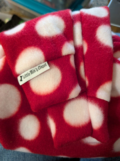 Folded red plush fleece Italian Greyhound bodysuit with large white polka dots and brand label