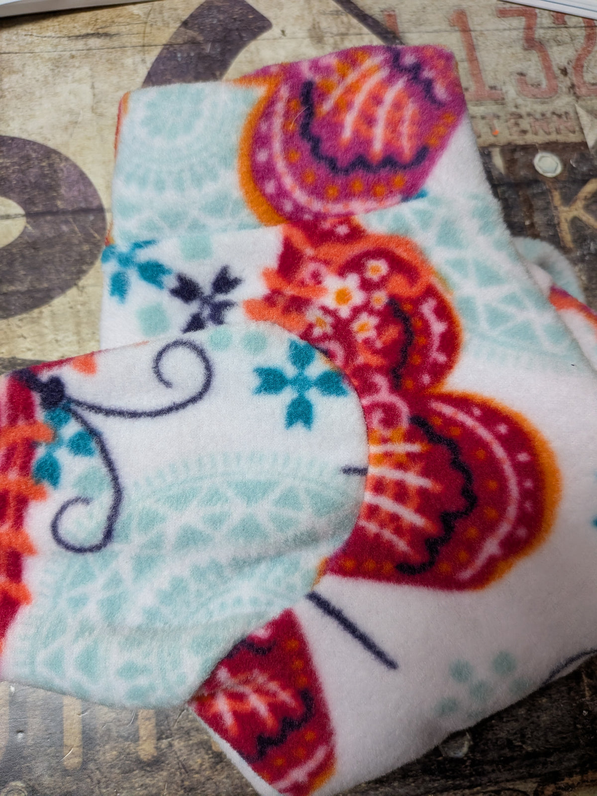 Folded white plush fleece bodysuit with red, pink and aqua paisley butterflies, extra small Italian Greyhound