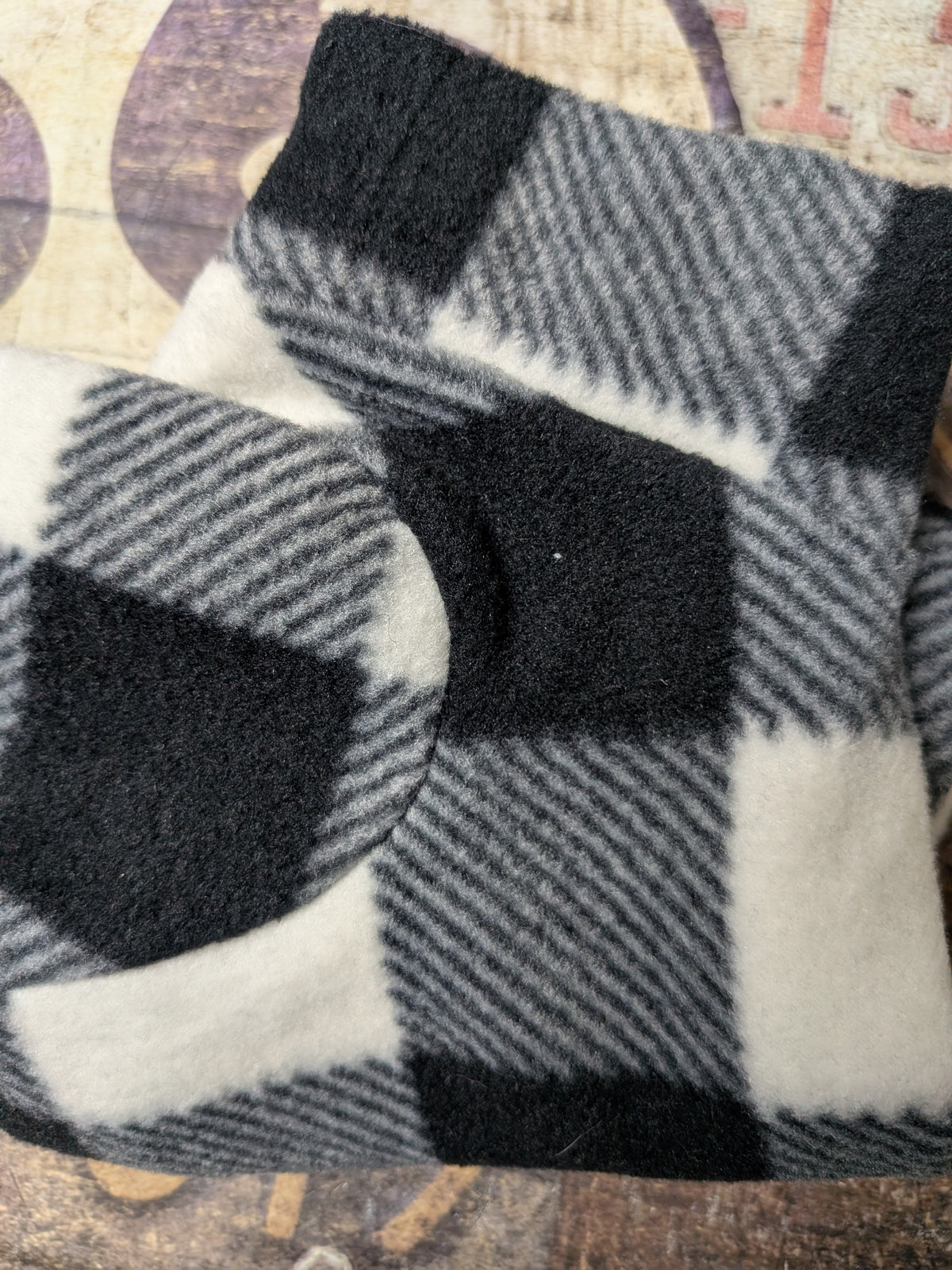 Folded black, white and grey buffalo check plush fleece bodysuit for an extra small Italian Greyhound