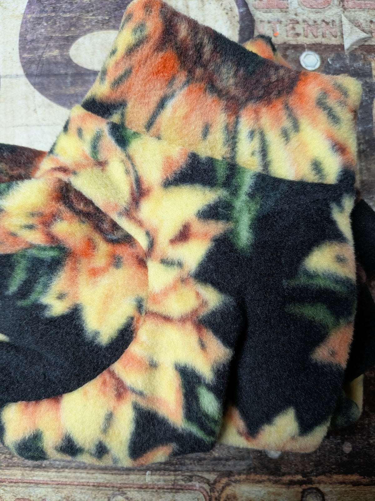 Folded black plush fleece Italian Greyhound bodysuit with golden yellow sunflowers