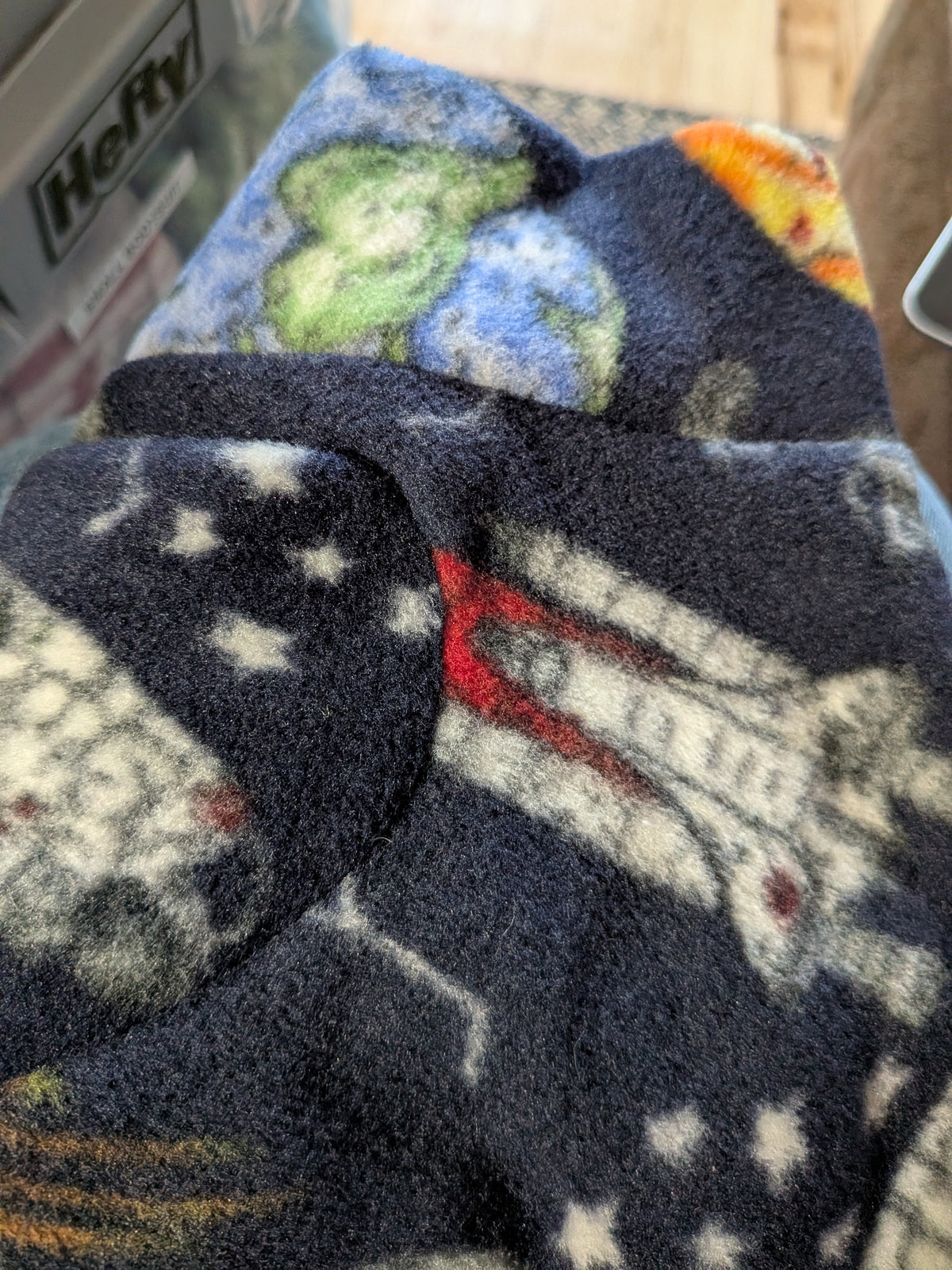 Folded navy outer space plush fleece bodysuit with stars and planets, extra small Italian Greyhound size