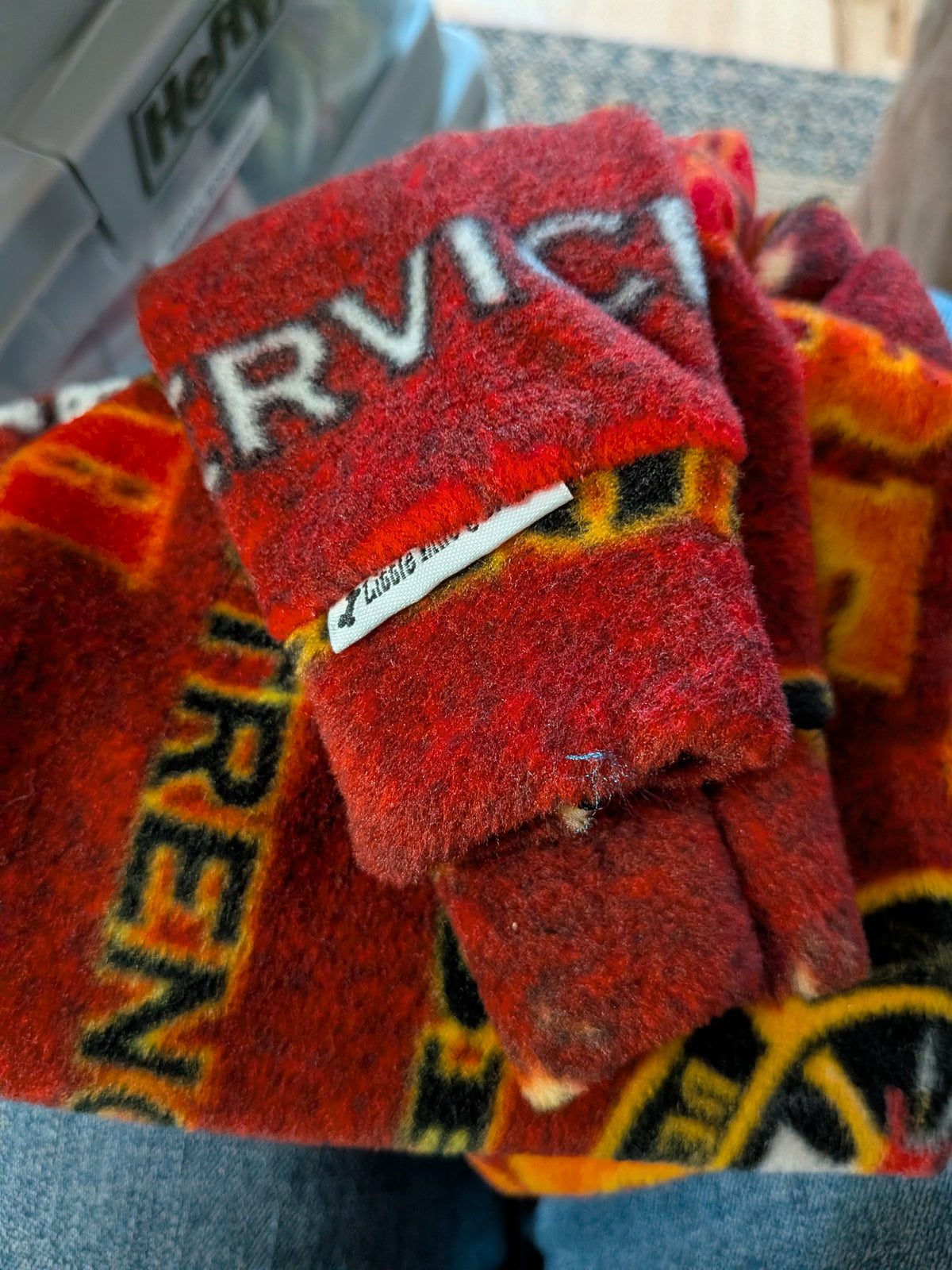 Folded red and orange firefighter print plush fleece bodysuit with Service and Siren text