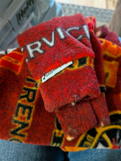 Folded red and orange firefighter print plush fleece bodysuit with Service and Siren text