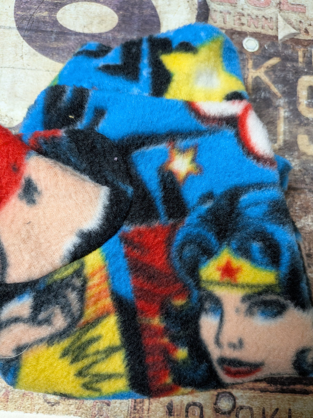 Folded blue comic book superhero print plush fleece bodysuit for an extra small Italian Greyhound