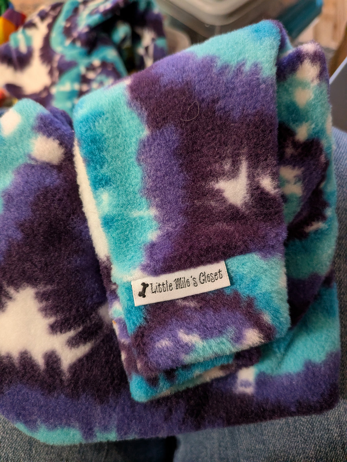 Folded purple and teal tie dye plush fleece Italian Greyhound bodysuit with brand label on the cuff