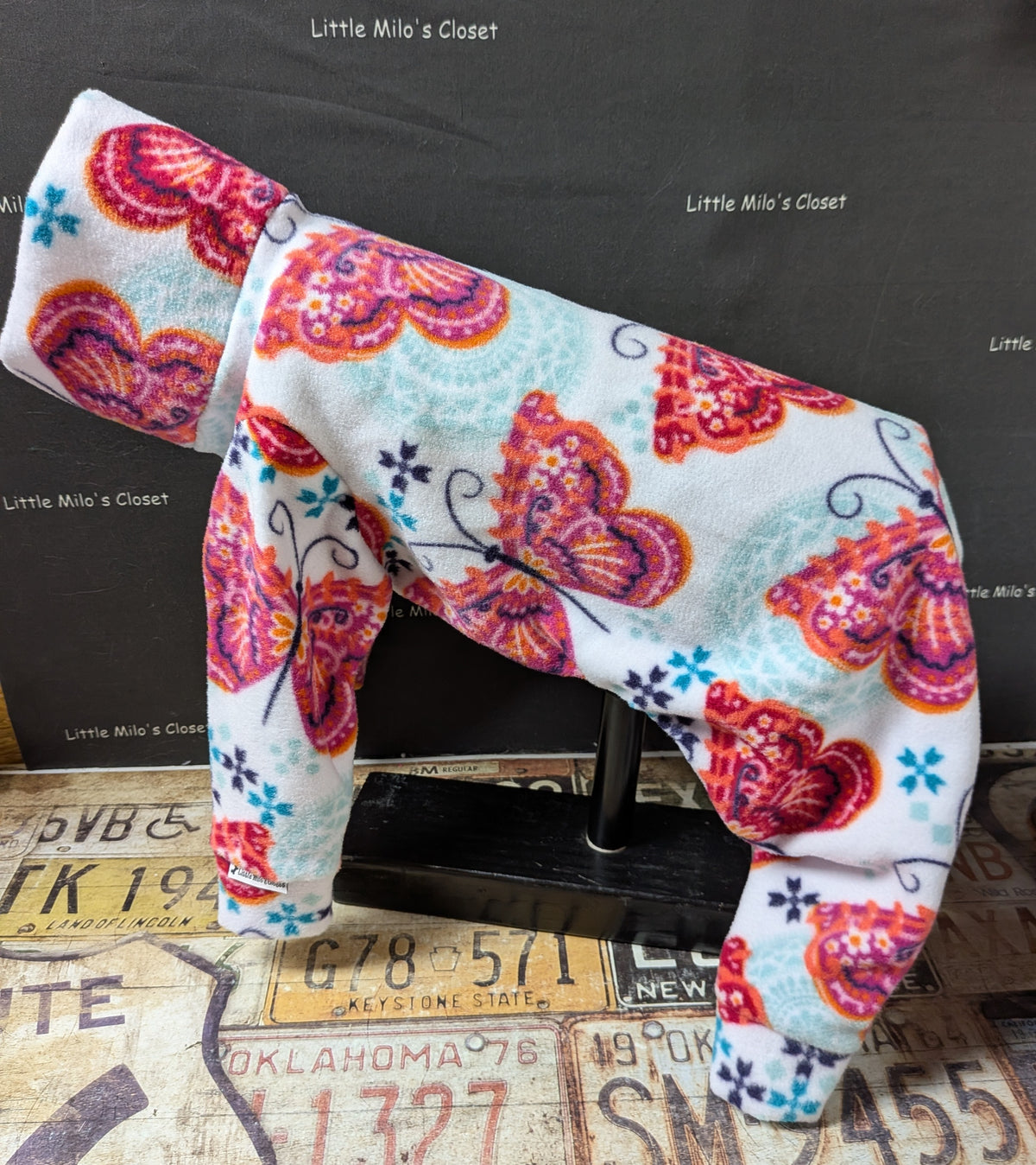 White fleece Italian Greyhound bodysuit with pink and orange paisley butterflies, side view on a dress form