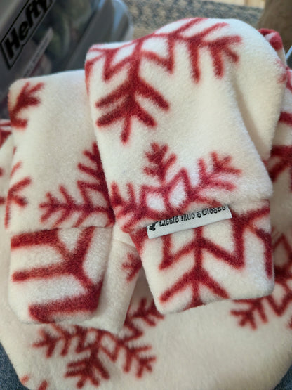 Folded white fleece Italian Greyhound bodysuit with large red snowflakes and the brand label