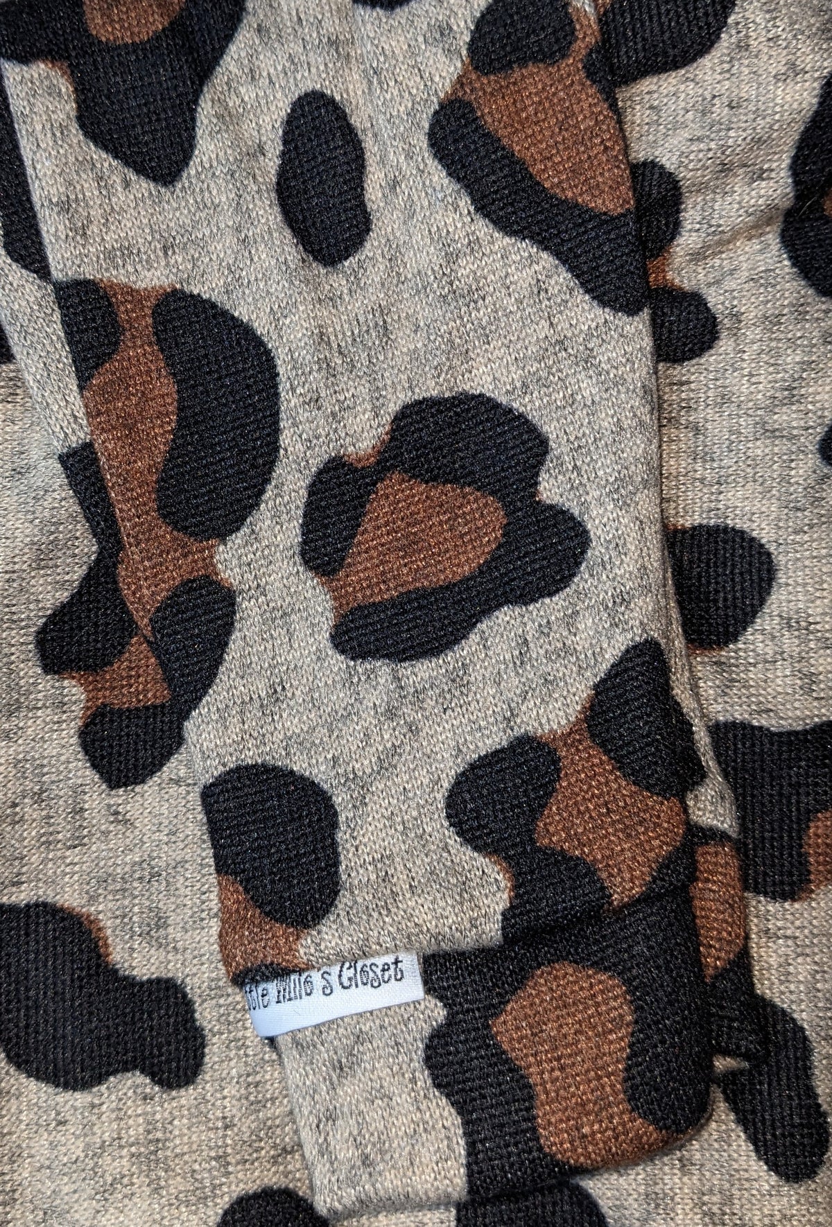 Close-up of the large cheetah print hacci knit sweater in tan, brown and black, folded flat