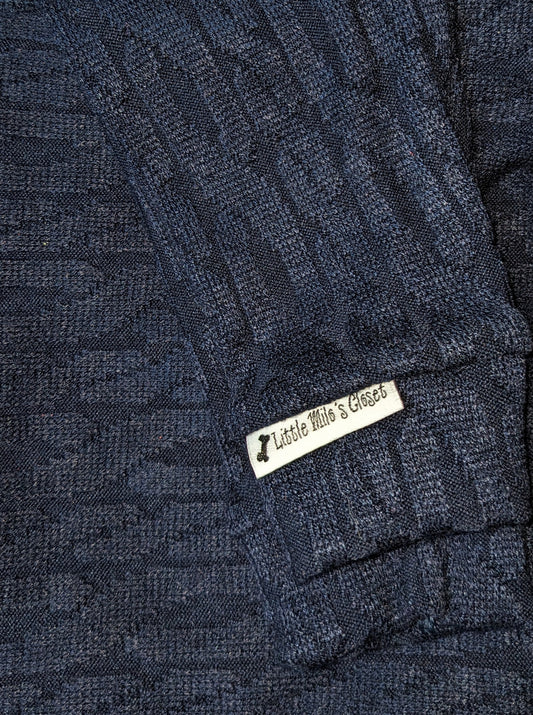 Navy blue cable knit Italian Greyhound sweater, folded close-up of the sleeve and label