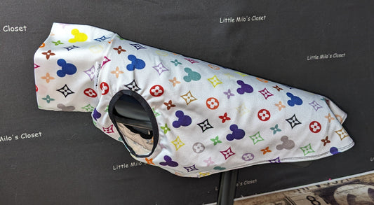 Designer Mouse medium UV sleeveless turtleneck vest, white with a colorful monogram print, on a dog form