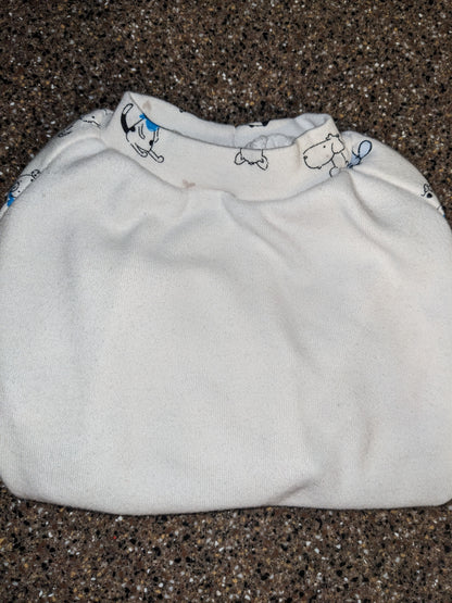 White upcycled dog shirt with a small cartoon dog print around the neckline, folded flat lay