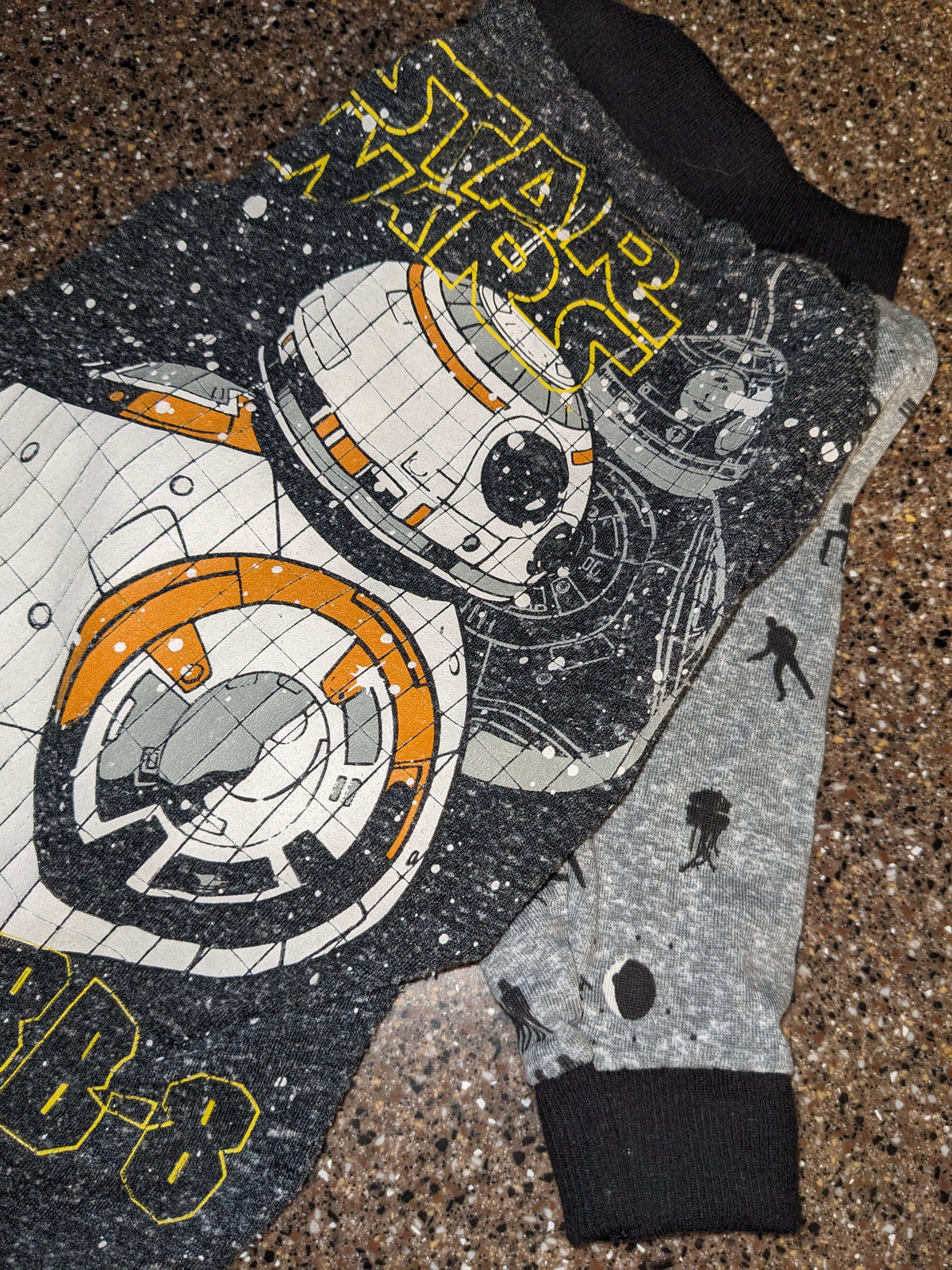 Upcycled Star Wars dog shirt with a BB-8 droid graphic on a dark starry print, grey sleeves, flat lay